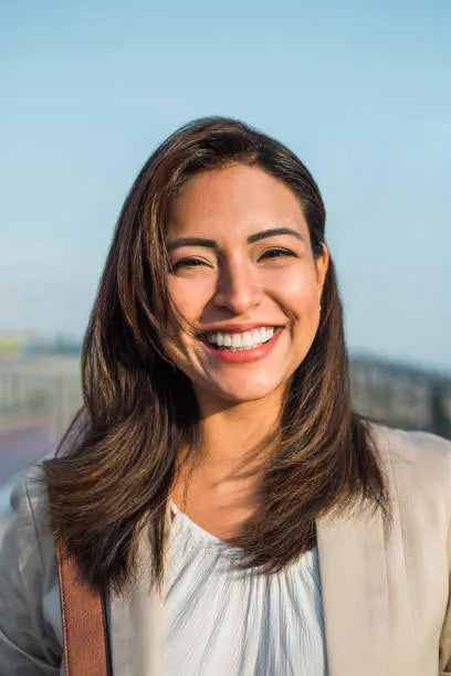 files/portrait-of-a-beautiful-latin-woman-smiling-outdoors-with-sunset-light-vertical-image.webp